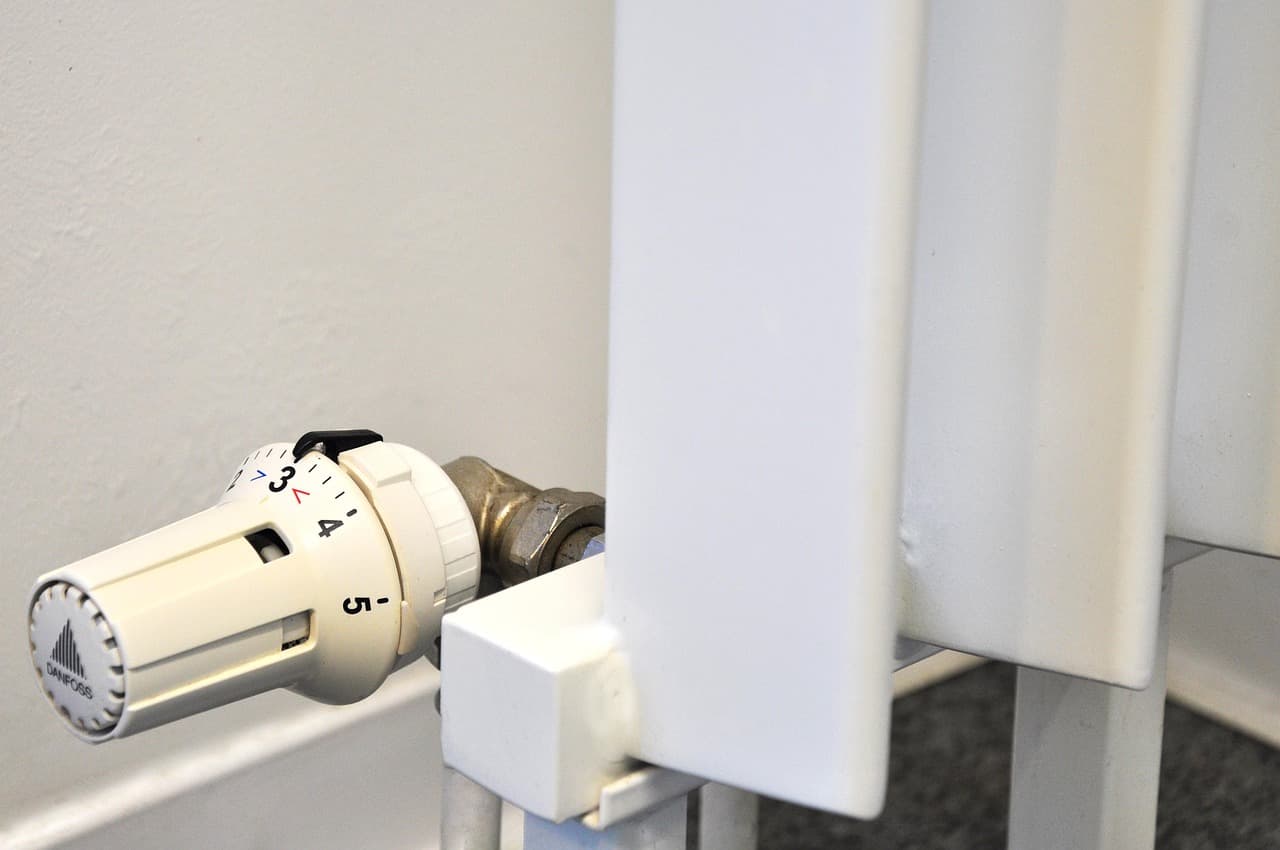 A thermostatic radiator valve on a white panel radiator